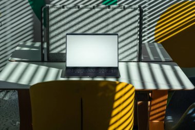 Laptop Workspace Shadows Light Ofis Alanı Yaratıcı modern ofis sahnesi, açık dizüstü bilgisayarı, dramatik güneş ışığının perdelerin arasından süzülmesi cesur çizgiler ve soyut şablonlar oluşturması, uzak çalışma veya dijital konsept için mükemmel bir model.