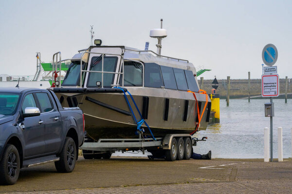 A high speed water taxi is loaded onto a boat trailer at the end of season in the harbor of Neuharlingersiel, Germany as winter starts