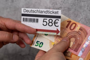 Elindeki Almanya bileti 58 avro, 50 ve 10 avroluk banknotlarla birlikte.