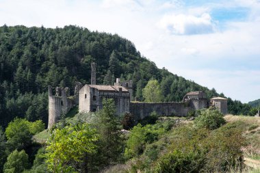 Kale harabesi ve Fransa 'da ormanın ortasında eski bir ev.