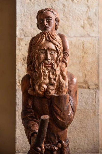 Religious wooden sculpture of a man with a child on his shoulders