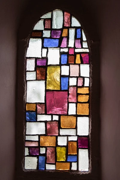 Texture of an abstract stained glass window with geometrical and coloured forms in a church