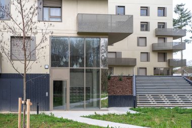 Balkonları olan modern bir apartmanın ön cephesi.