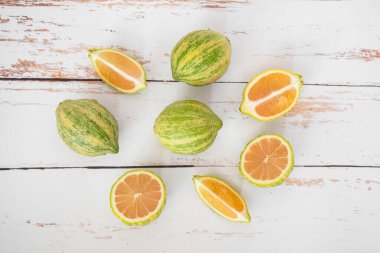 Beyaz ahşap arka planda çizgili pembe limonlar.