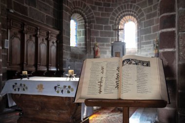 Dini bir sunağın önündeki kilisede bir kitle kitabı ya da açık bir İncil.