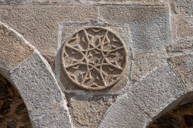 Fransa 'da Dordogne' da bir ortaçağ duvarındaki bir roset biçimindeki geometrik heykelin ayrıntıları