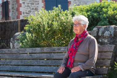 Fransa 'da tipik bir evin önünde Brittany' de oturan yaşlı bir kadının portresi.
