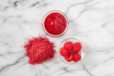 Kurutulmuş ahududu tozu ve yanında ahududu.