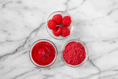 Kurutulmuş ahududu tozu ve yanında ahududu.