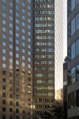 Paris, Fransa 'da modern cam bir binanın cephesinde güneşin yansıması.