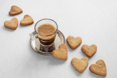 Sevgililer Günü için bir fincan kahve ve kalp şeklinde kurabiye.