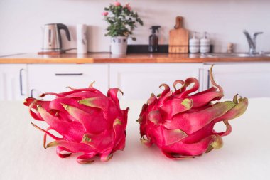 Bütünü yakın çekim ve mutfak masasında kırmızı ejderha meyvesi kesme.