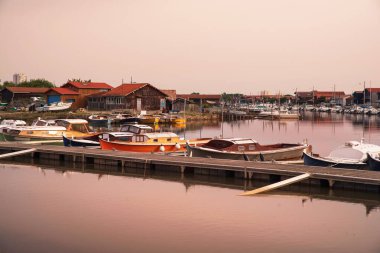 Pinasse, Fransa 'daki Arcachon Havzası' ndan tipik bir tekne, istiridye kulübeleri olan bir limanda.