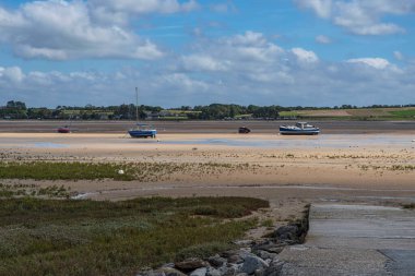 Pontoon at the Pointe d'Agon in Normandy, France, with boats at low tide clipart