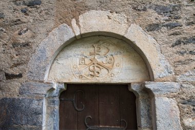 Detail of the sculpture above the entrance door to the Templar chapel at Aragnouet in the Pyrenees clipart