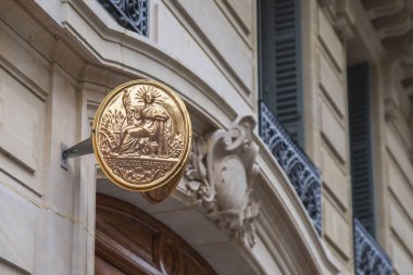 Üzerinde Fransızca yazılar olan altın kaplama noter tabelası: Fransa Cumhuriyeti, bir binanın ön cephesinde