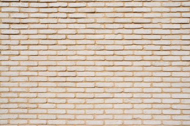 Küçük bej tuğlalardan oluşan bir duvarın dokusu
