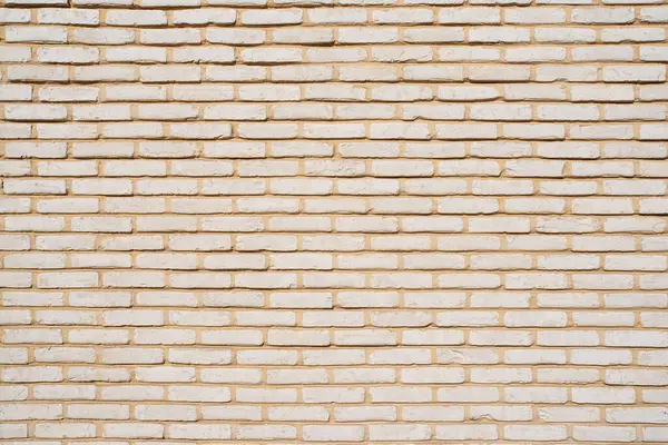 Küçük bej tuğlalardan oluşan bir duvarın dokusu
