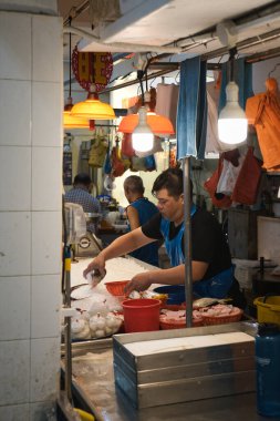 Singapur - 28 Eylül 2022: Yishun çevre yolundaki HDB blok 848 'deki yerel bir balıkçı ve deniz ürünleri tezgahında balıkçı.