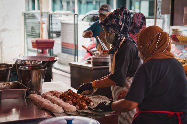Penang, Malezya - 1 Kasım 2022: Malezyalı kadınlar, Sri Kaynak Gıda Mahkemesi 'ndeki ünlü Ali Nasi Lemak Daun Pisang' da yemek hazırlıyor.