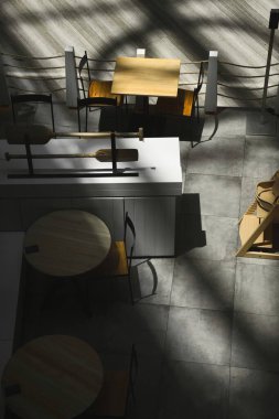 Kafe restoranında boş masa ve sandalyeler. Güneş ışığı ve zıt gölgeler var..