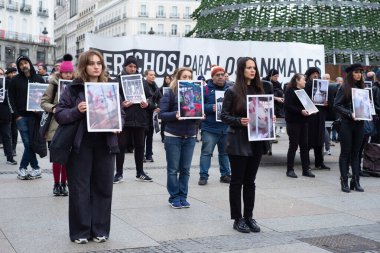 Dünya Hayvan Hakları Günü 'nde Puerta del Sol' da 9 Aralık 2023 'te İspanya' nın Madrid kentinde düzenlenen bir gösteride düzinelerce insan hayvan fotoğrafları tutuyor..