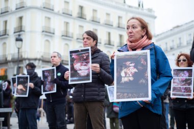 Dünya Hayvan Hakları Günü 'nde Puerta del Sol' da 9 Aralık 2023 'te İspanya' nın Madrid kentinde düzenlenen bir gösteride düzinelerce insan hayvan fotoğrafları tutuyor..