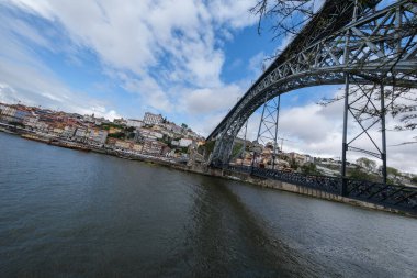 Portekiz 'de 15 Nisan 2024 tarihinde Porto ve Vila Nova de Gaia şehirleri arasında Douro Nehri boyunca uzanan çift katlı metal kemer köprüsünün görüntüsü..