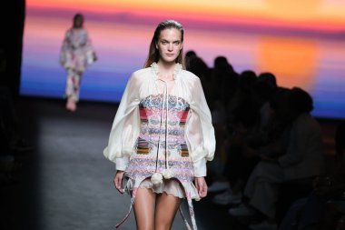 IFERMA 'da Mercedes-Benz Moda Haftası Madrid' de 12 Eylül 2024 'te Odette Alvarez' in tasarladığı tasarımı giyen bir model podyumda yürüyor.