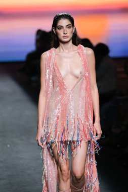 IFERMA 'da Mercedes-Benz Moda Haftası Madrid' de 12 Eylül 2024 'te Odette Alvarez' in tasarladığı tasarımı giyen bir model podyumda yürüyor.