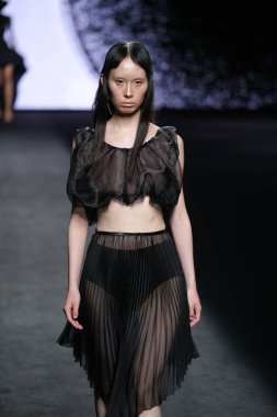 IFERMA 'da Mercedes-Benz Moda Haftası sırasında De la Cierva y Nicolas tarafından tasarlanmış bir tasarım giyen bir model podyumda yürüyor, 12 Eylül 2024 İspanya