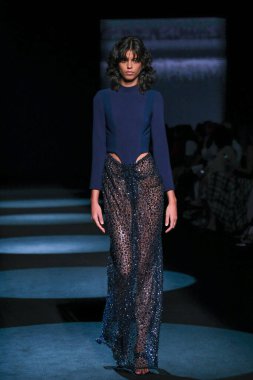 13 Eylül 2024 'te İspanya' nın IFERMA şehrinde Mercedes-Benz Moda Haftası sırasında Jc Pajares tarafından tasarlanmış bir tasarım giyen bir model podyumda yürüyor.