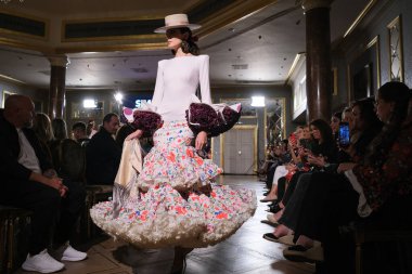 27 Eylül 2024 tarihinde Madrid, İspanya 'da bulunan Wellington Hotel' de düzenlenen Uluslararası Flamenko Moda Haftası Madrid 'de (SIMOF) Moda Flamenka tasarımı içinde yürüyen bir model görülüyor.