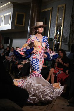 27 Eylül 2024 tarihinde Madrid, İspanya 'da bulunan Wellington Hotel' de düzenlenen Uluslararası Flamenko Moda Haftası Madrid 'de (SIMOF) Moda Flamenka tasarımı içinde yürüyen bir model görülüyor.