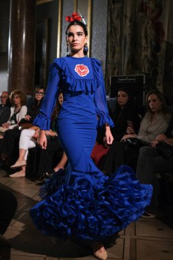 27 Eylül 2024 tarihinde Madrid, İspanya 'da bulunan Wellington Hotel' de düzenlenen Uluslararası Flamenko Moda Haftası Madrid 'de (SIMOF) Moda Flamenka tasarımı içinde yürüyen bir model görülüyor.