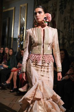 27 Eylül 2024 tarihinde Madrid, İspanya 'da bulunan Wellington Hotel' de düzenlenen Uluslararası Flamenko Moda Haftası Madrid 'de (SIMOF) Moda Flamenka tasarımı içinde yürüyen bir model görülüyor.