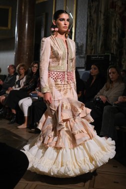 27 Eylül 2024 tarihinde Madrid, İspanya 'da bulunan Wellington Hotel' de düzenlenen Uluslararası Flamenko Moda Haftası Madrid 'de (SIMOF) Moda Flamenka tasarımı içinde yürüyen bir model görülüyor.