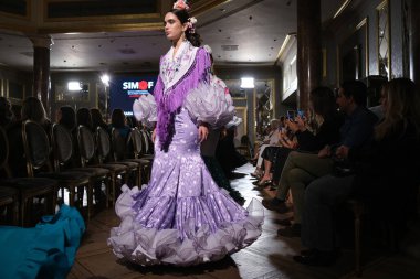 27 Eylül 2024 tarihinde Madrid, İspanya 'da bulunan Wellington Hotel' de düzenlenen Uluslararası Flamenko Moda Haftası Madrid 'de (SIMOF) Moda Flamenka tasarımı içinde yürüyen bir model görülüyor.