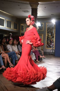27 Eylül 2024 tarihinde Madrid, İspanya 'da bulunan Wellington Hotel' de düzenlenen Uluslararası Flamenko Moda Haftası Madrid 'de (SIMOF) Moda Flamenka tasarımı içinde yürüyen bir model görülüyor.