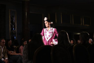 27 Eylül 2024 tarihinde Madrid, İspanya 'da bulunan Wellington Hotel' de düzenlenen Uluslararası Flamenko Moda Haftası Madrid 'de (SIMOF) Moda Flamenka tasarımı içinde yürüyen bir model görülüyor.