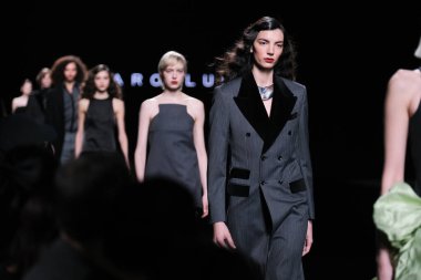 20 Şubat 2025 'te İspanya' nın IFERMA şehrinde Mercedes-Benz Moda Haftası sırasında Baro Lucas 'ın tasarladığı bir tasarımı giyen bir model podyumda yürüyor.