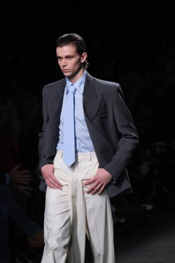 20 Şubat 2025 'te İspanya' nın IFERMA şehrinde Mercedes-Benz Moda Haftası sırasında Mans tarafından tasarlanmış bir tasarım giyen bir model podyumda yürüyor.