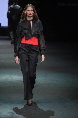 IFERMA 'da Mercedes-Benz Moda Haftası sırasında Pedro del Hierro tarafından tasarlanmış bir tasarım giyen bir model podyumda yürüyor, 20 Şubat 2025 İspanya