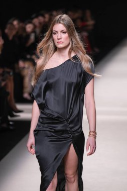 20 Şubat 2025 'te İspanya' nın IFERMA şehrinde Mercedes-Benz Moda Haftası sırasında Alex Riviere tarafından tasarlanmış bir tasarım giyen bir model podyumda yürüyor.