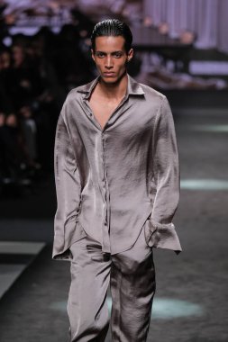 21 Şubat 2025 'te İspanya' nın IFERMA şehrinde Mercedes-Benz Moda Haftası sırasında Erroz 'un tasarladığı bir tasarım giyen bir model podyumda yürüyor.