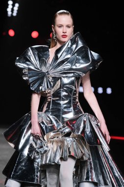 23 Şubat 2025 'te İspanya' nın IFERMA şehrinde Mercedes-Benz Moda Haftası sırasında David Moss tarafından tasarlanan bir model podyumda yürüyor.