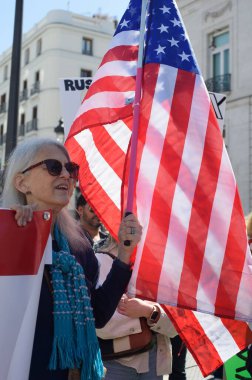 29 Mart 2025 'te Madrid' deki Puerta del Sol 'da düzenlenen Trump karşıtı protesto sırasında bayraklı göstericiler.