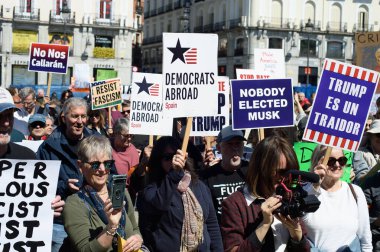 29 Mart 2025 'te Madrid' deki Puerta del Sol 'da düzenlenen Trump karşıtı protesto sırasında bayraklı göstericiler.