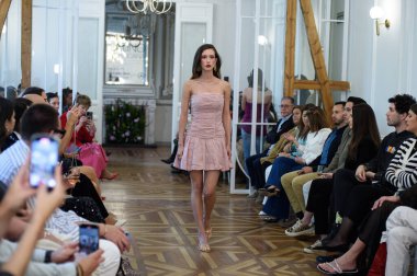 Moda haftası boyunca IFERMA 'da Latin Amerika tasarımı giyen bir model podyumda yürüyor. 9 Mayıs 2025 İspanya