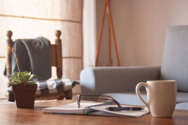 Oturma odasında güneşli bir öğleden sonra masanın üstünde sanal iş eşyaları var..